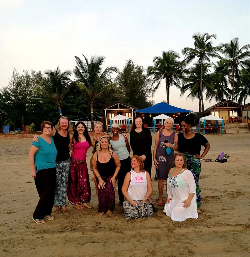 A group sharing a moment on the beach beneath palm trees