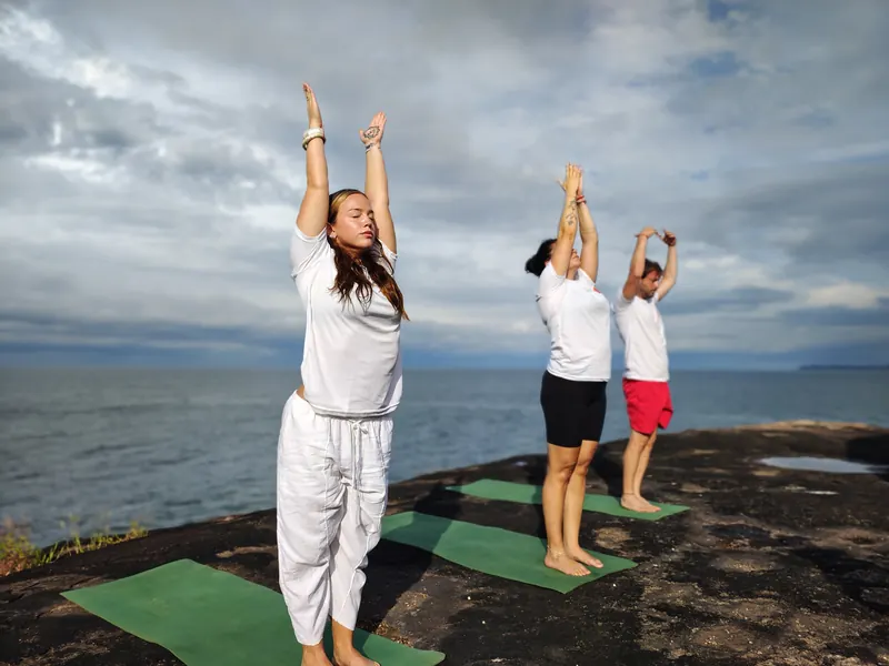 Yoga participants stretching beside the sea in Goa