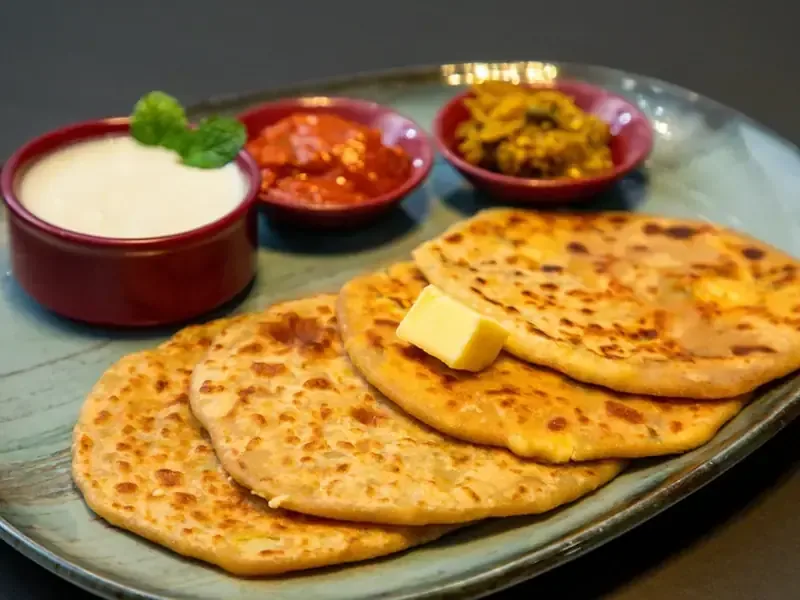 Freshly prepared paratha with accompaniments
