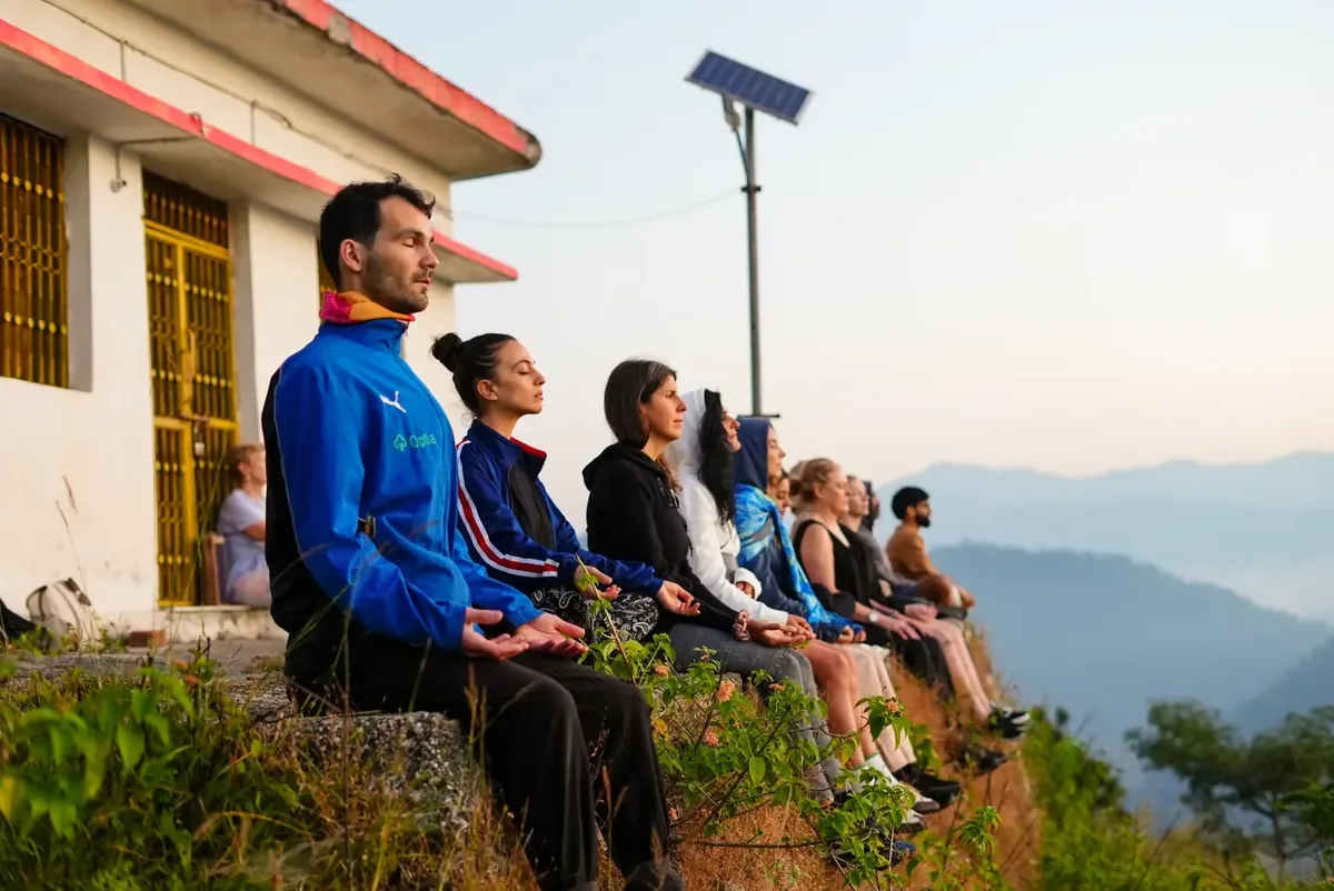 Participants seated outdoors overlooking the Himalayan foothills