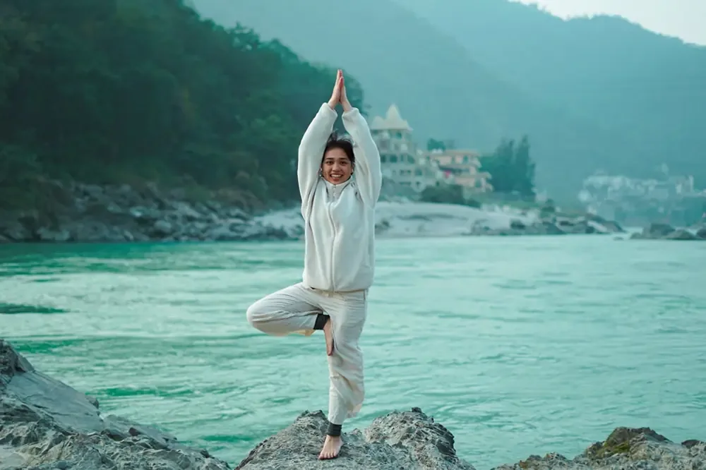 Tree pose beside the Ganges during a yoga retreat in Rishikesh