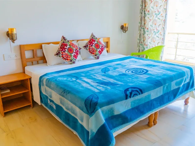Bedroom with a wooden bed and colourful bedding